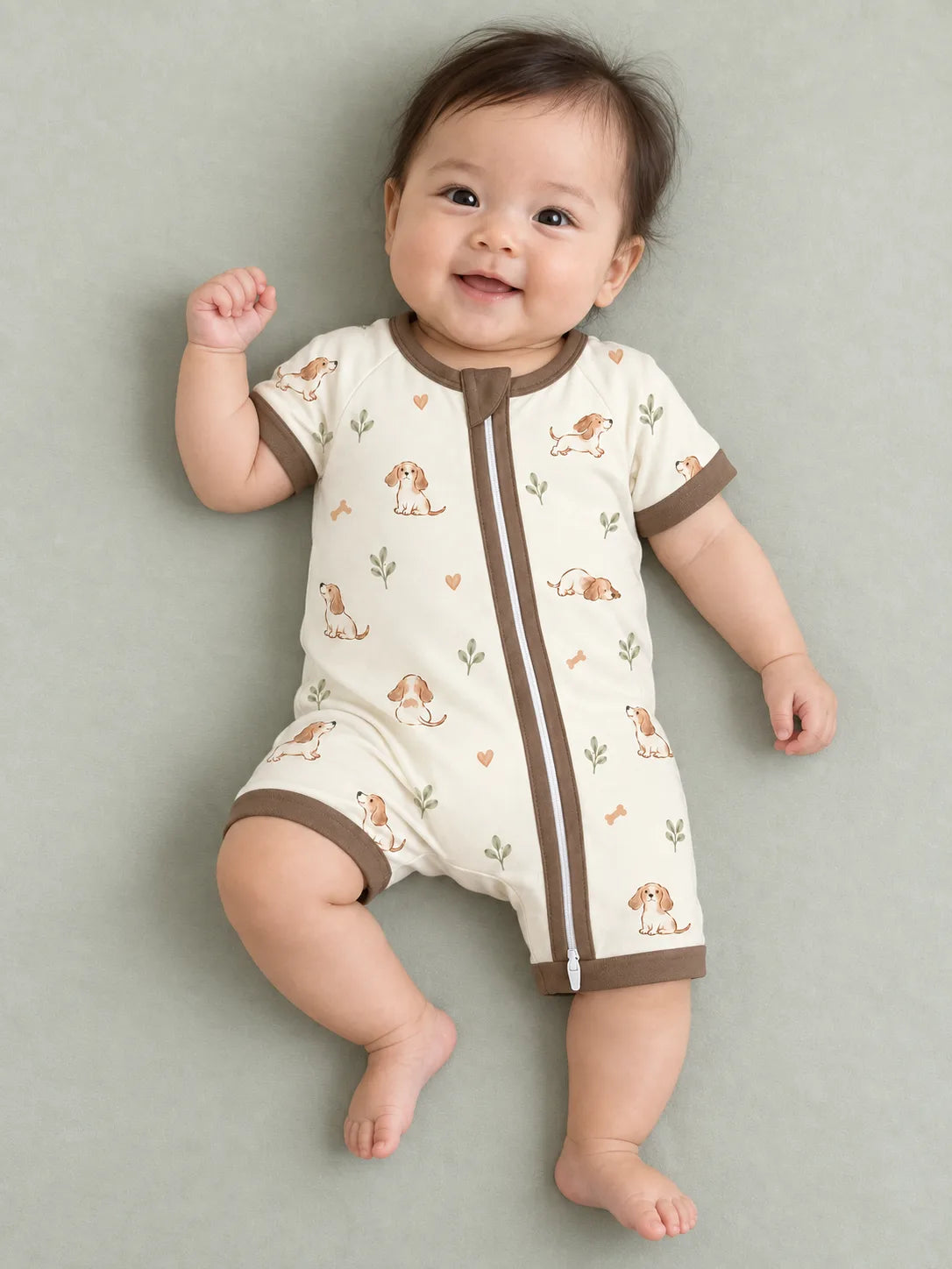 Baby wearing the MossiBaby doxie dreams shorty romper against a pale studio backdrop