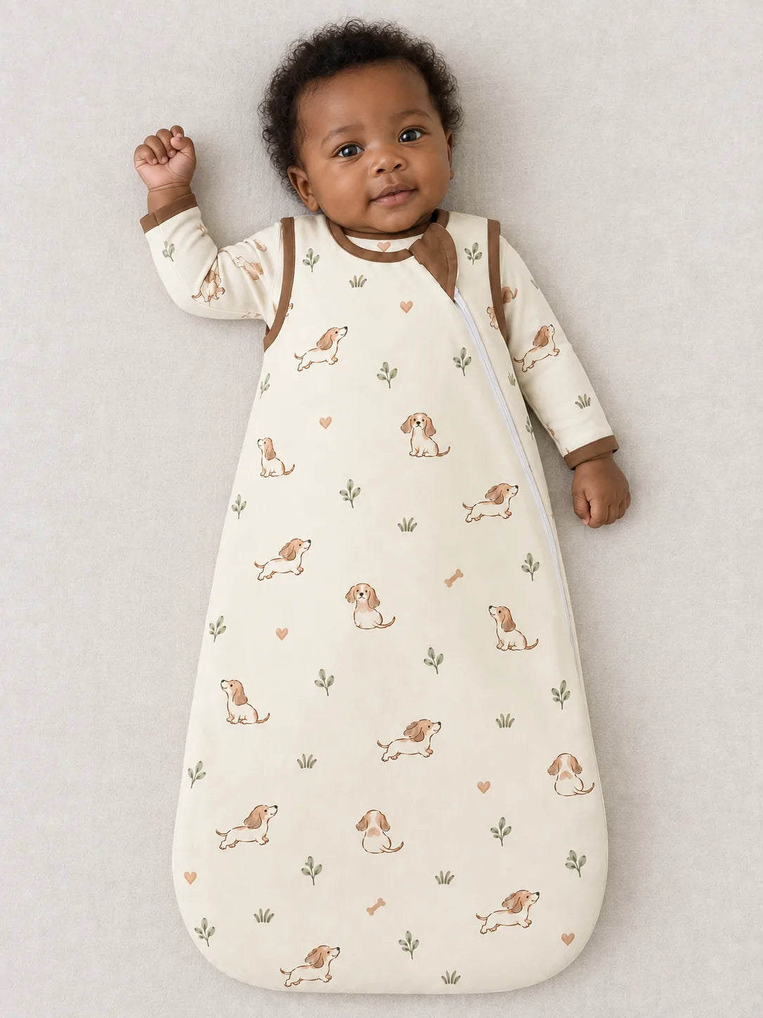 Baby wearing the MossiBaby doxie dreams sleep bag against a pale studio backdrop