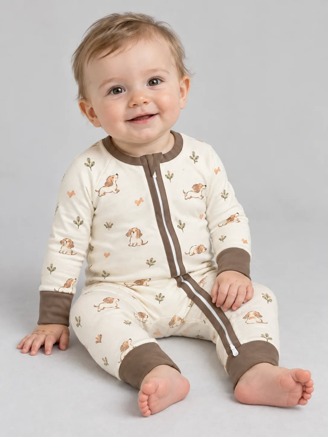 Baby wearing the MossiBaby doxie dreams zipper romper against a pale studio backdrop