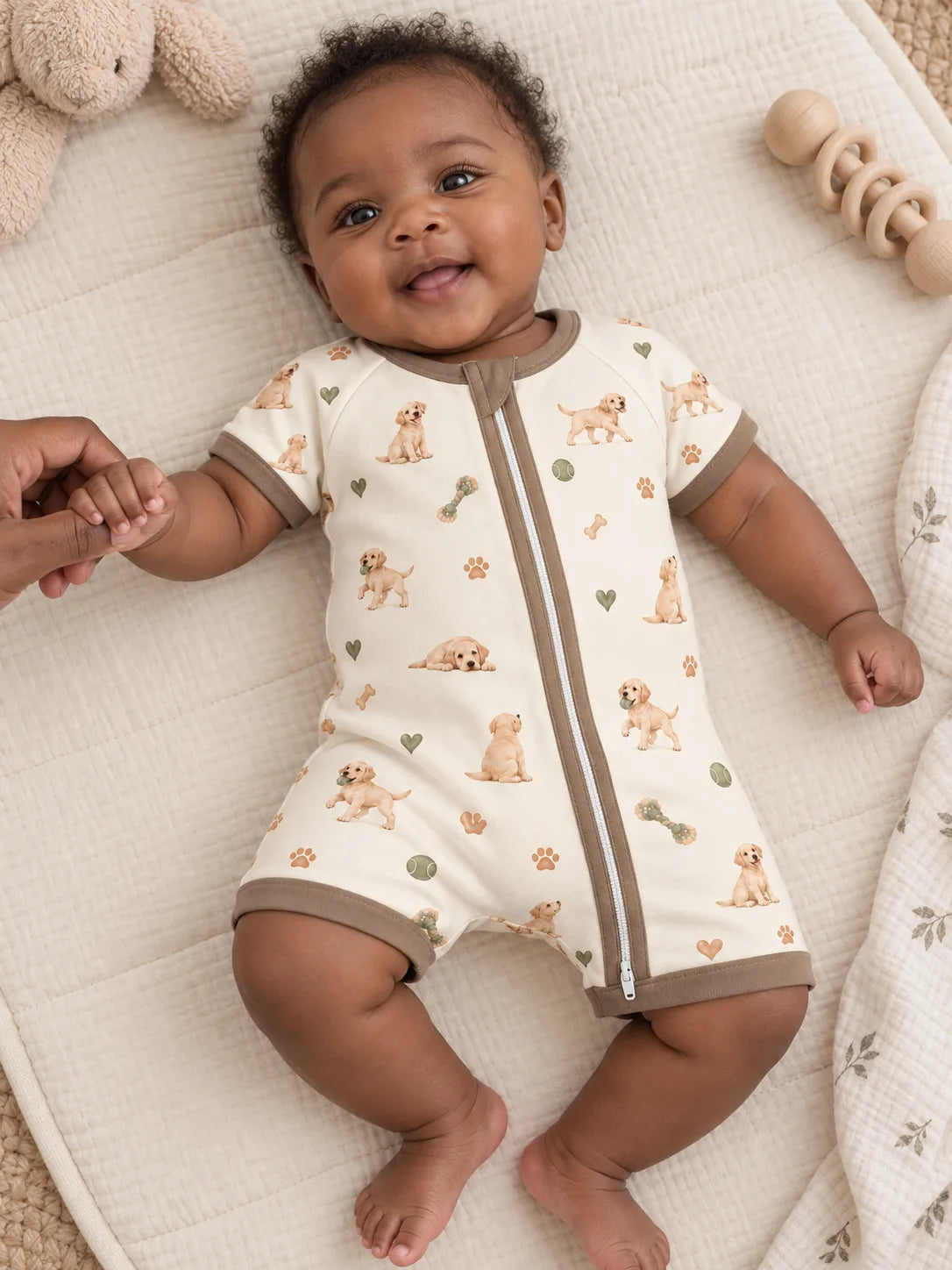 Baby wearing the MossiBaby little labradors shorty romper in an indoor lifestyle scene