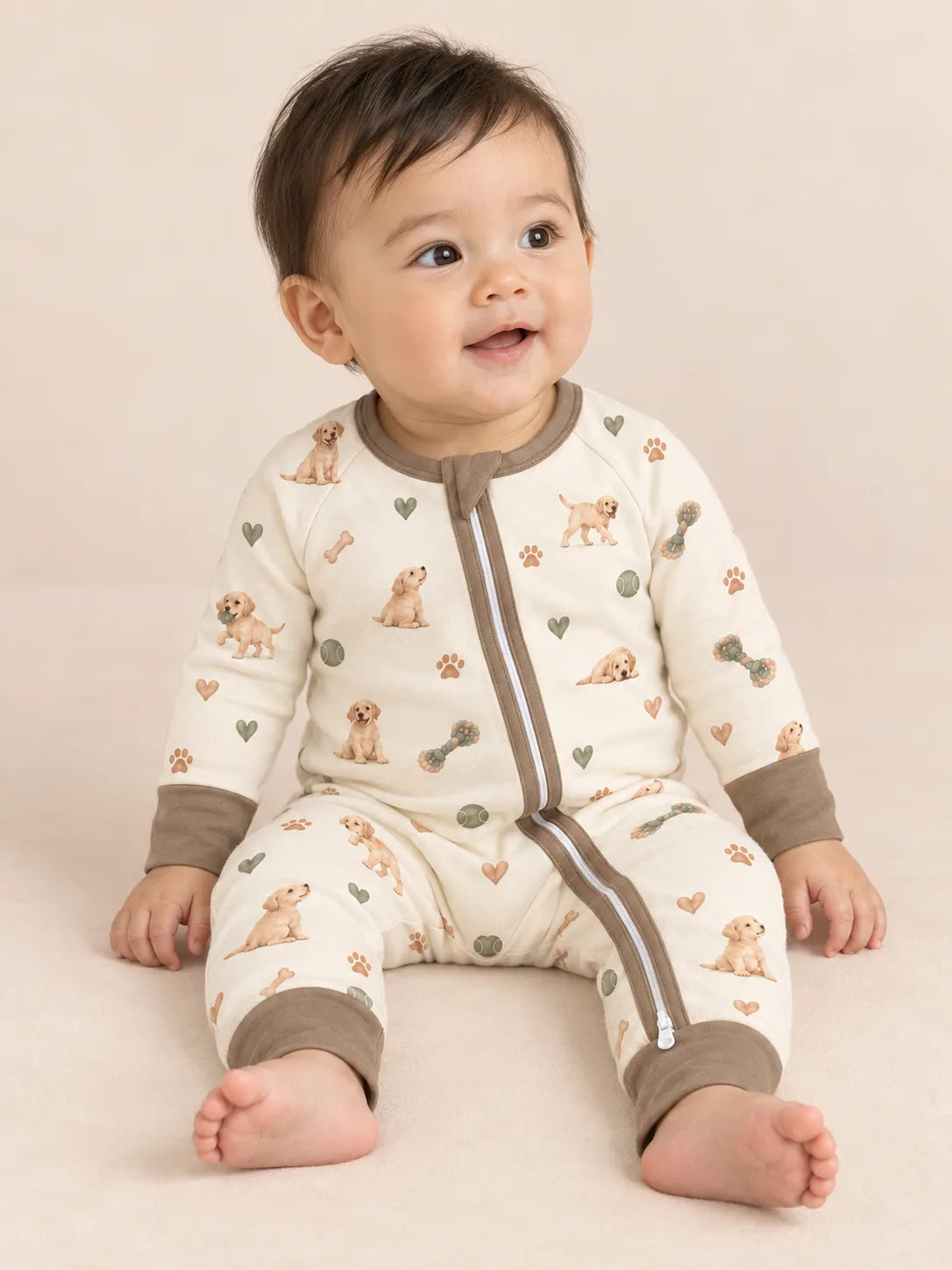 Baby wearing the MossiBaby little labradors zipper romper against a pale studio backdrop
