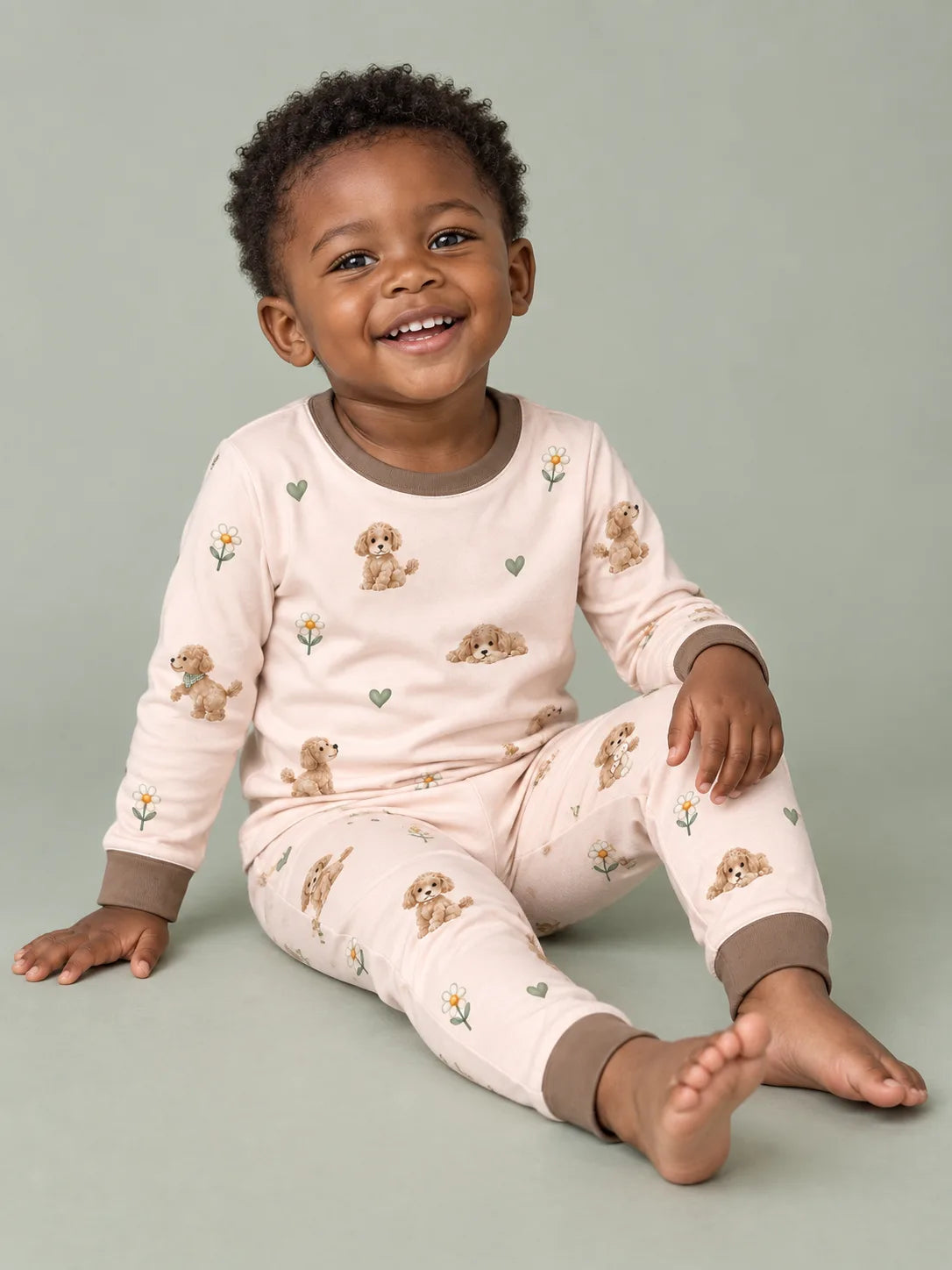 Child wearing the MossiBaby poodle petals long sleeve pajama set against a pale studio backdrop