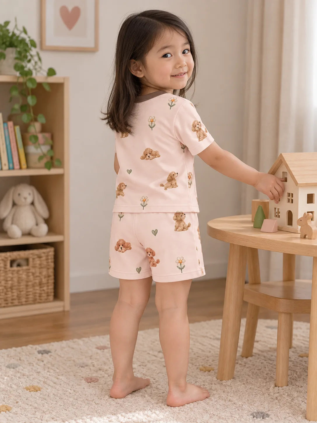 Child wearing the MossiBaby poodle petals short sleeve pajama set in an indoor lifestyle scene