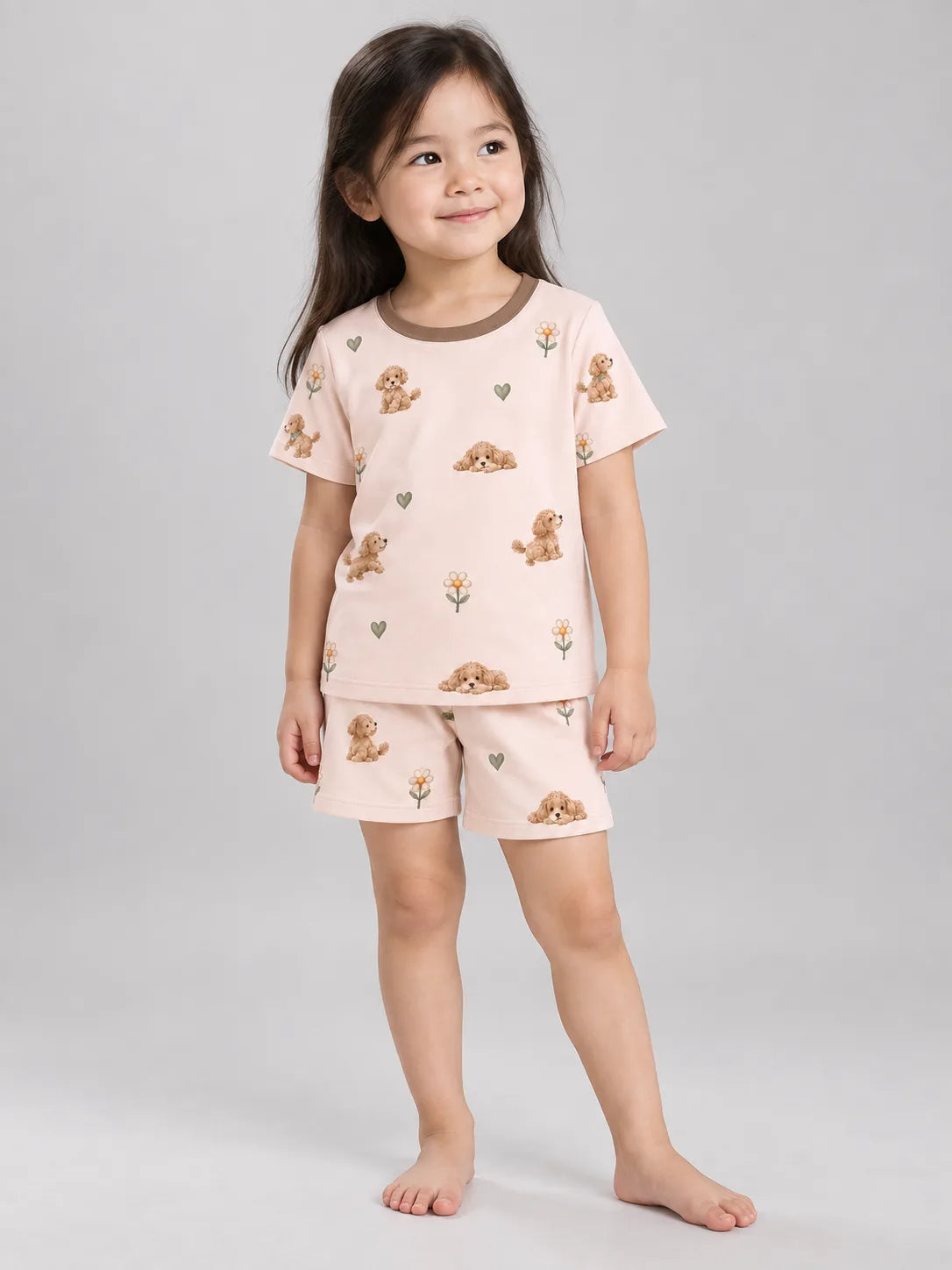 Child wearing the MossiBaby poodle petals short sleeve pajama set against a pale studio backdrop