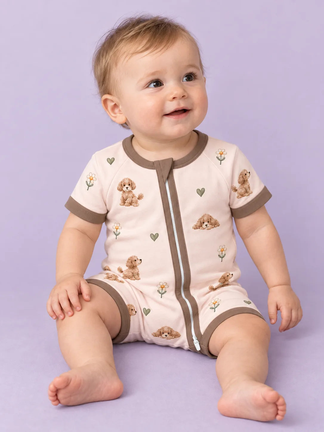 Baby wearing the MossiBaby poodle petals shorty romper against a pale studio backdrop