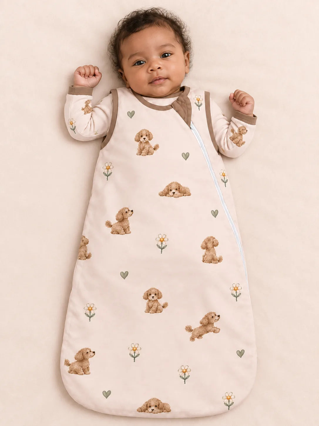 Baby wearing the MossiBaby poodle petals sleep bag against a pale studio backdrop