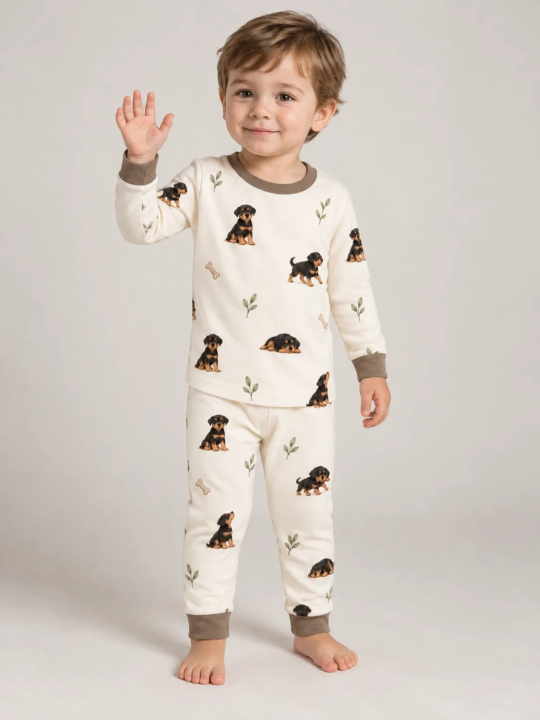 Child wearing the MossiBaby rottie cuddles long sleeve pajama set against a pale studio backdrop