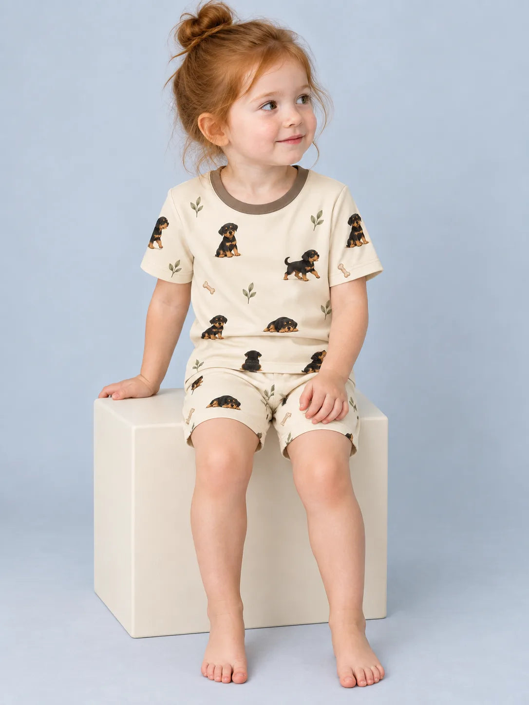 Child wearing the MossiBaby rottie cuddles short sleeve pajama set against a pale studio backdrop