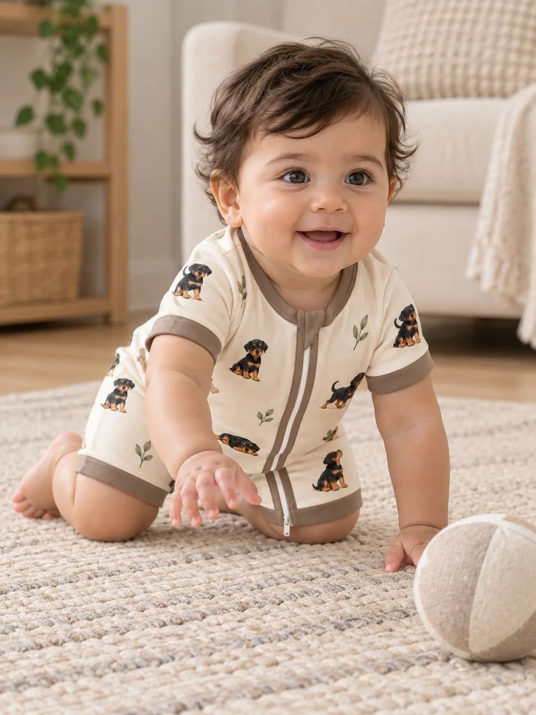 Baby wearing the MossiBaby rottie cuddles shorty romper in an indoor lifestyle scene