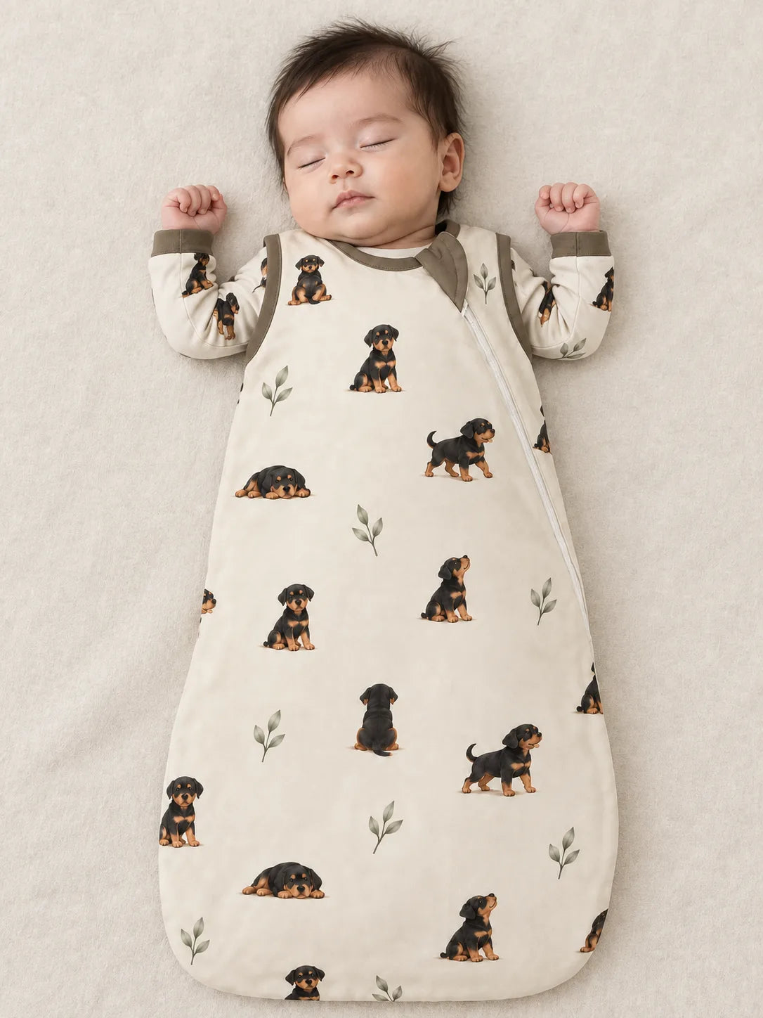 Baby wearing the MossiBaby rottie cuddles sleep bag against a pale studio backdrop