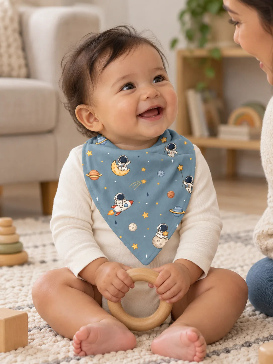 Baby wearing a denim blue Space Adventures bamboo bandana bib during playtime at home