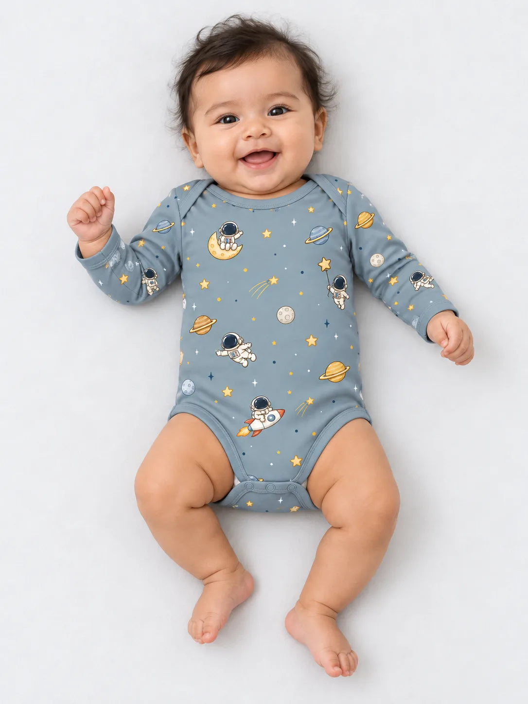 Baby wearing Mossibaby Space Adventures denim blue bamboo long sleeve bodysuit in a studio