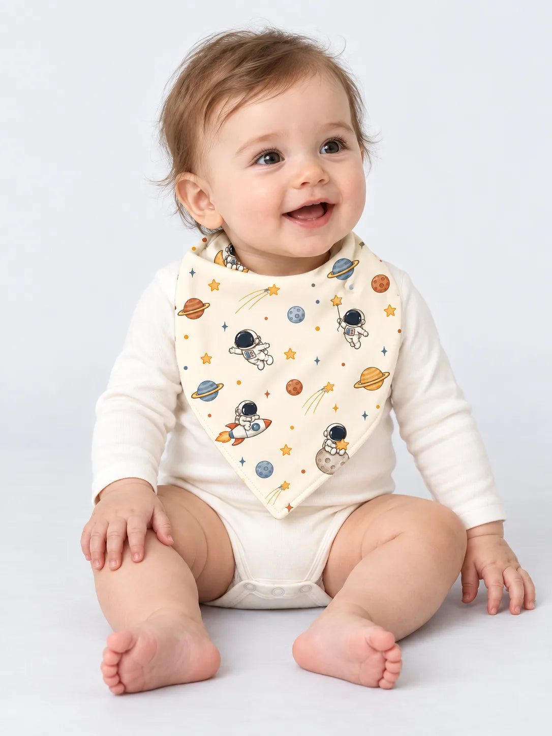 Baby wearing Mossibaby Space Adventures ivory bamboo bandana bib in a studio