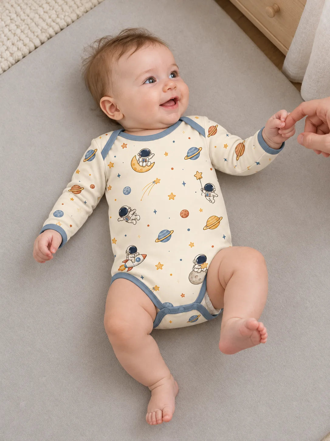 Baby enjoying playtime at home in an ivory Space Adventures bamboo bodysuit