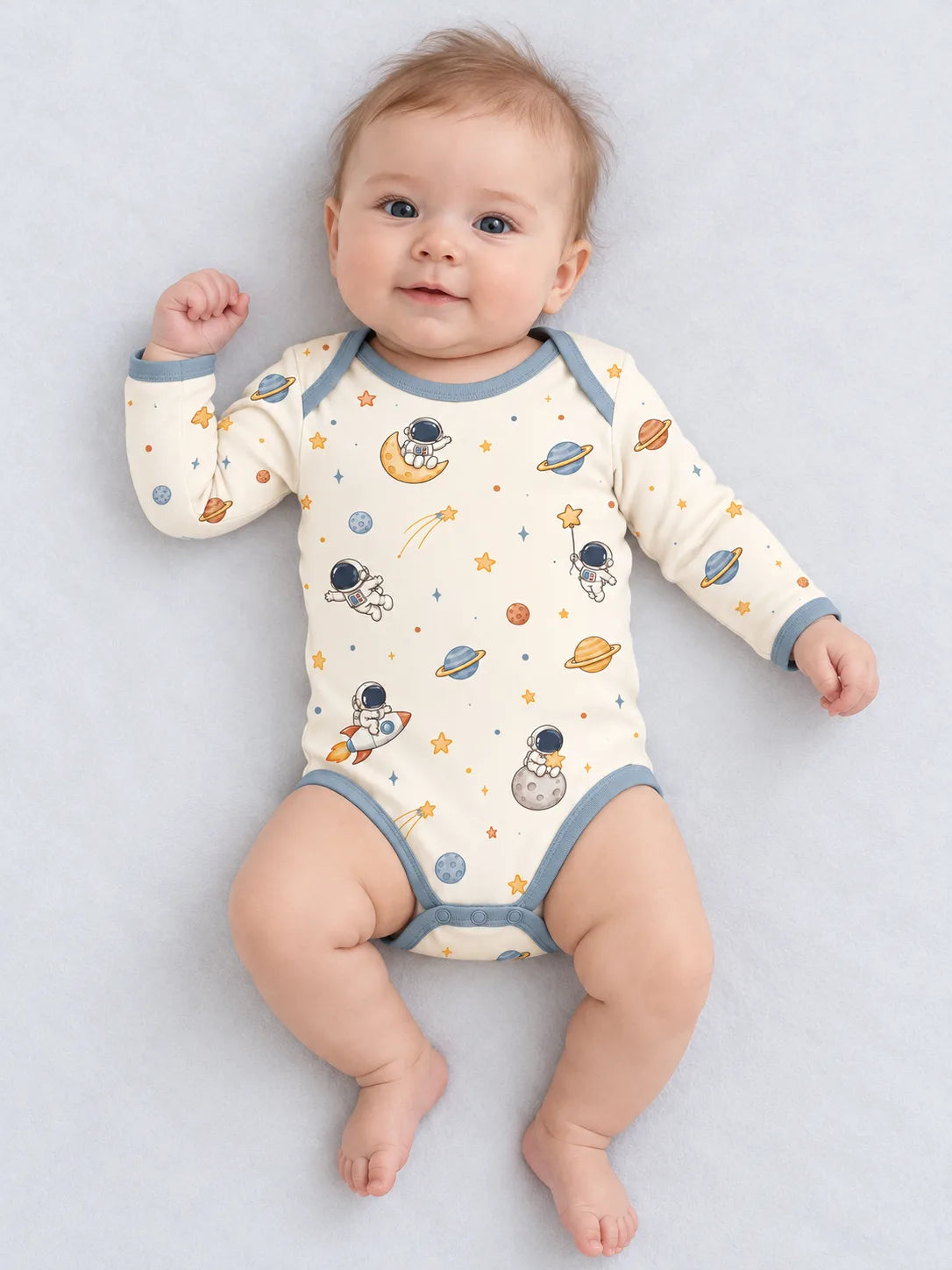 Baby wearing Mossibaby Space Adventures ivory bamboo long sleeve bodysuit in a studio